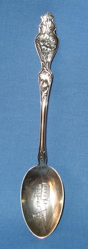 Souvenir Mining Spoon Oroville CA.JPG - SOUVENIR MINING SPOON GOLD DREDGER OROVILLE CA - Sterling silver spoon with engraved bowl showing gold dredge and marked GOLD DREDGER OROVILLE CAL, top of handle shows California Poppy (state flower), 5 1/8 in. long, reverse marked Sterling (Oroville, CA is situated at the base of the foothills on the banks of the Feather River where it flows out of the Sierra Nevada onto the flat floor of the Sacramento Valley. It was established as the head of navigation on the Feather River to supply gold miners during the California Gold Rush.  The Feather River is one of the main river systems in California’s Mother Lode region. It is the major tributary to the Sacramento River, and was one of the first areas that gold was discovered during the gold rush in 1849.  Settled in 1849, Oroville originally was known as Ophir City, but the name was changed when the first post office opened in 1854.  Gold was discovered here at a site called Bidwell Bar, one of the earliest mining sites in California, bringing in thousands of miners.  The early miners worked the area by hand using shovels, picks, gold pans, and sluice boxes, and found the entire area to be exceptionally rich with gold dust and nuggets.  Around 1895, W. P. Hammon and others tested the area to determine the feasibility of mining on a large scale. They introduced bucket-line dredging in 1898, the first in California. The field was highly productive from 1903 to 1916; in 1908 there were 35 dredges and 12 dredging companies active in the field.  Output later declined, but dredging was done again from 1936 to 1942 and 1945 to 1952. The dredge field is now an important source of sand and gravel.  Throughout the history of dredging in California the Oroville district has floated more dredges and seen more dredging companies than any other areas in California.  Output from dredging in the Oroville area is estimated to be about 1,964,000 ounces of gold.)